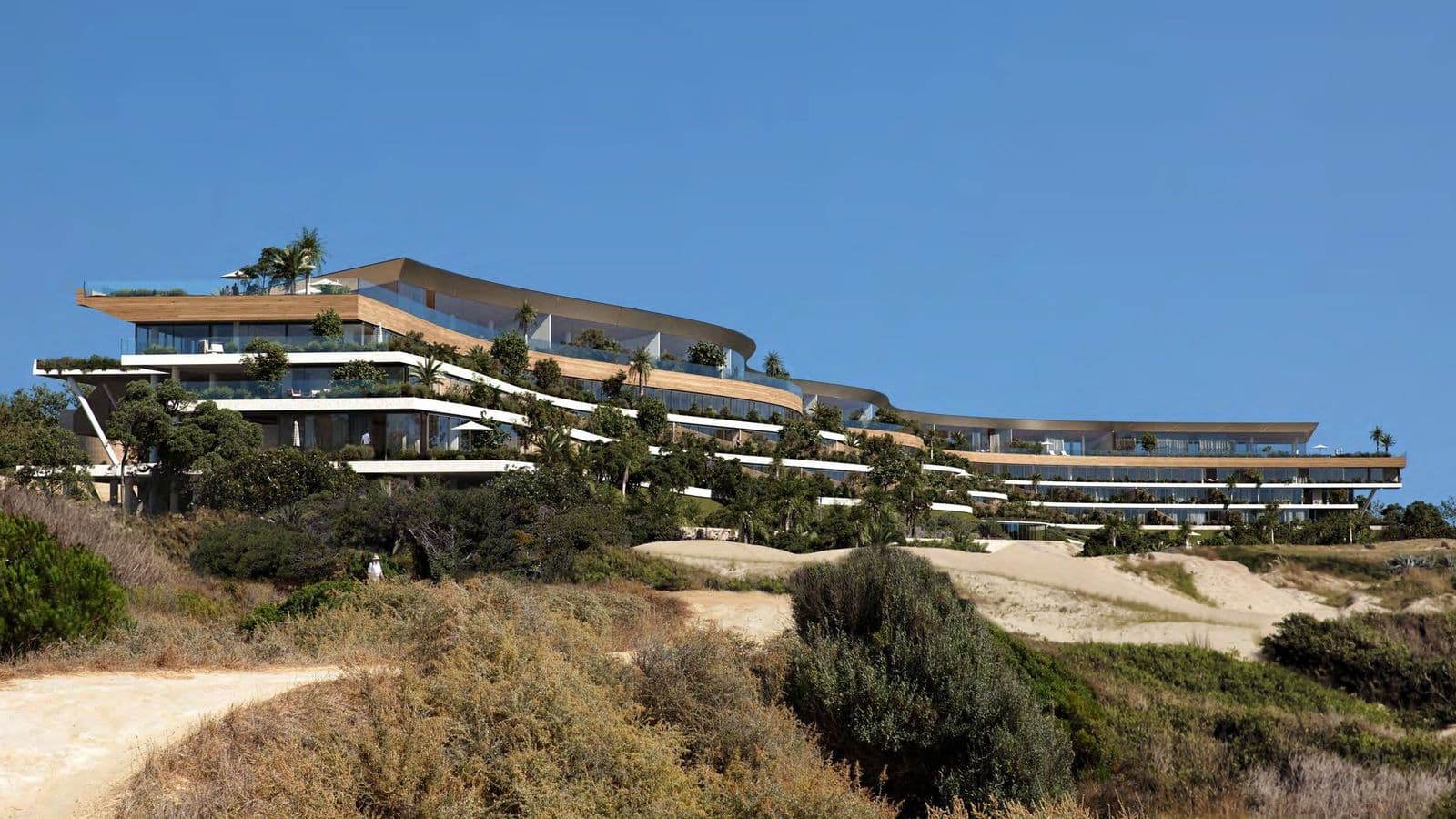 Médano seen from the dunes, its low terraced form set into the landscape
